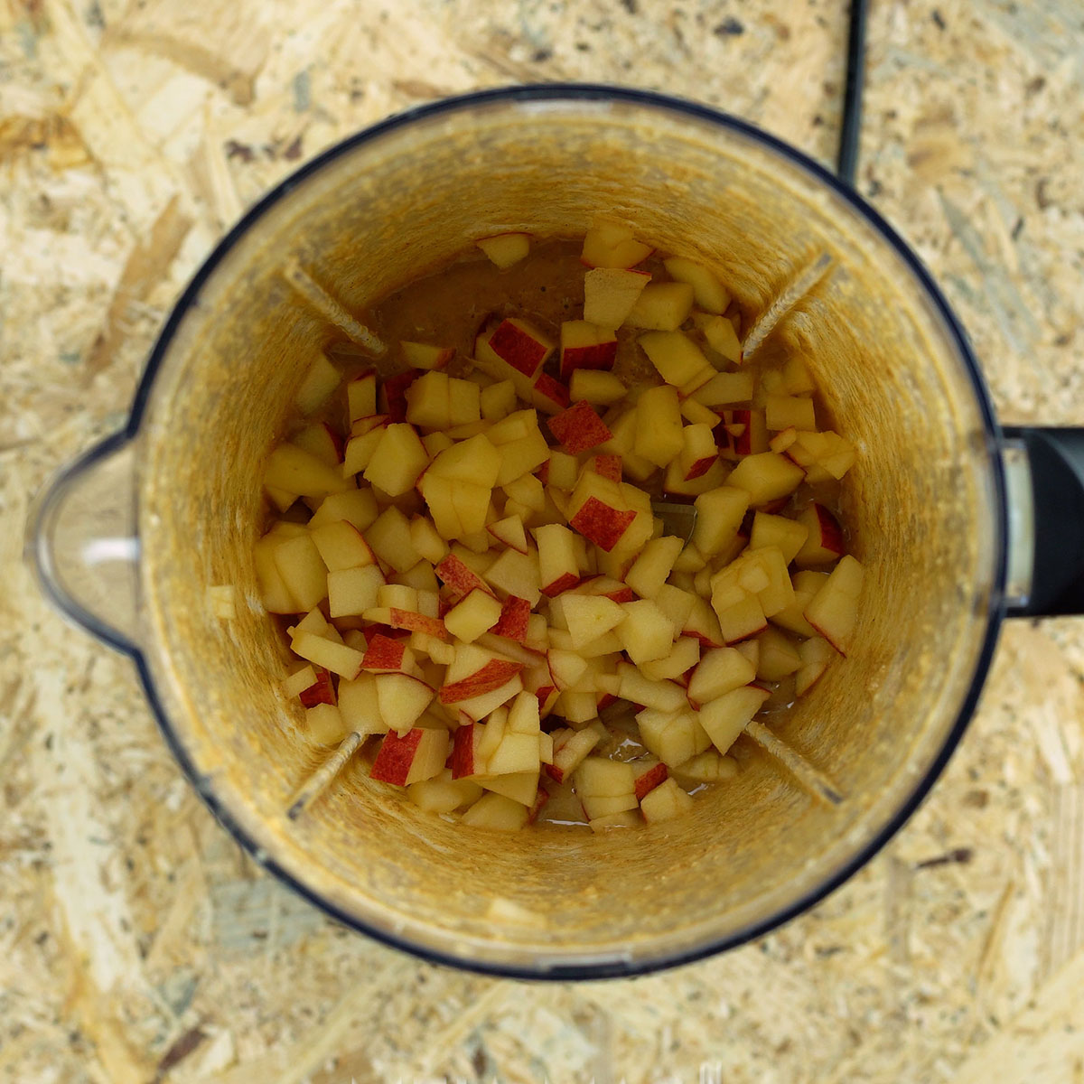 Gehackter Apfel wird zum Teig für Apfel-Hafer-Muffins gegeben.