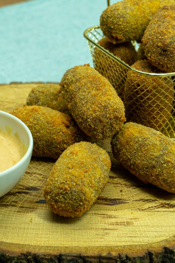Fertige Fleischkroketten werden mit einem Dip serviert.