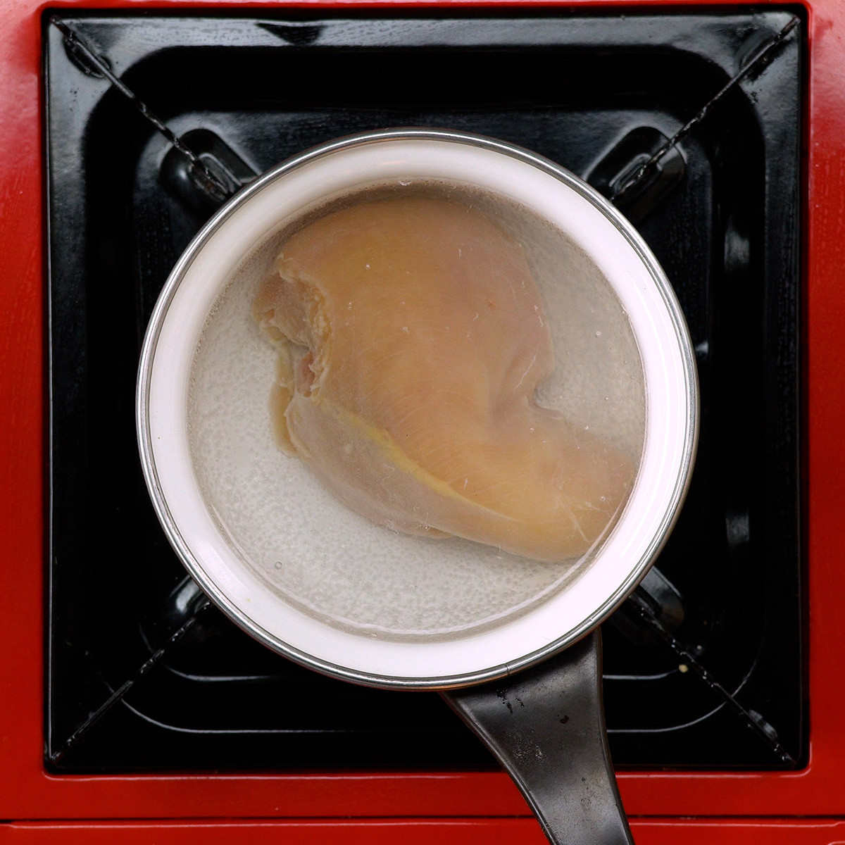 Hähnchenbrust wird gekocht und anschließend gezupft.