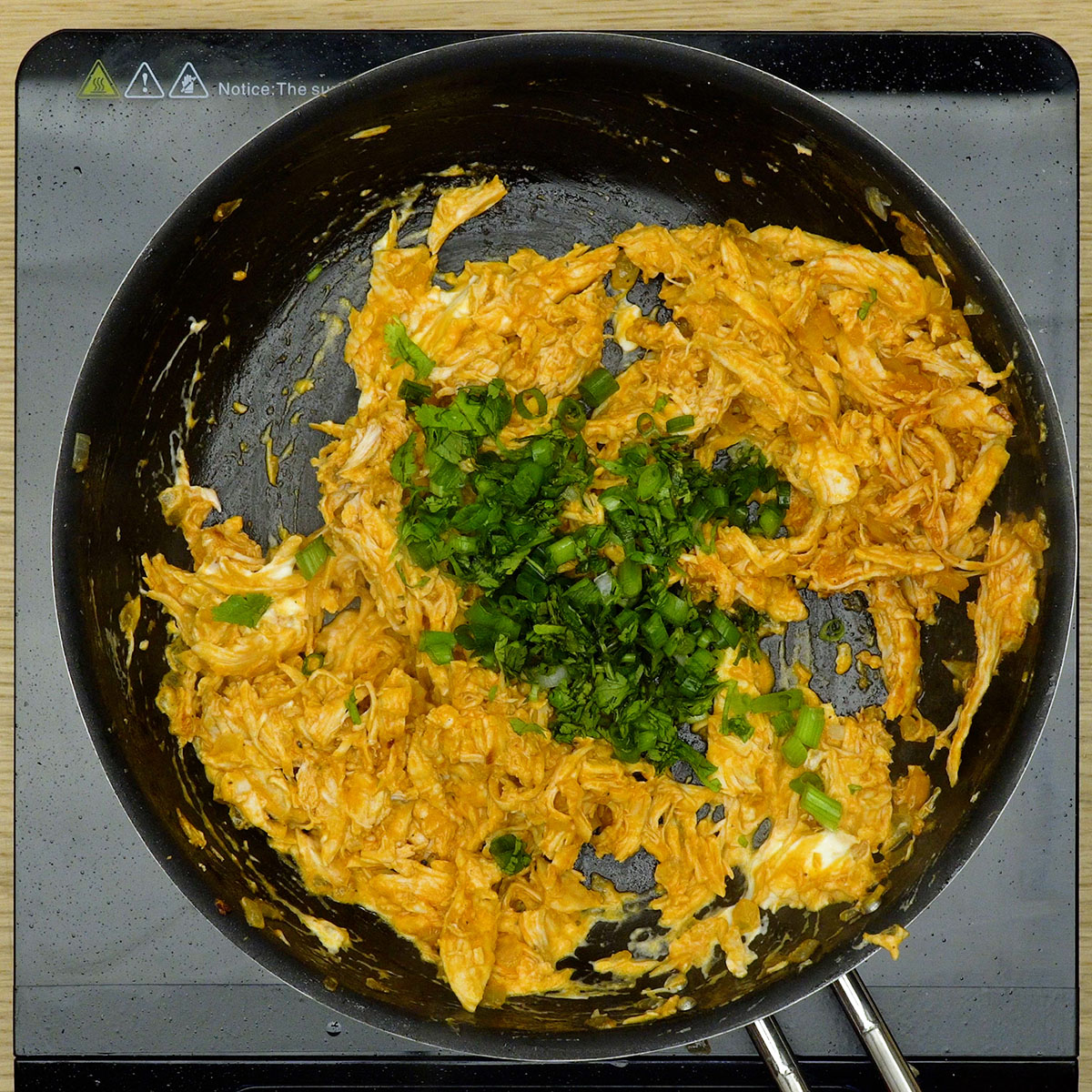 Hähnchenfüllung mit Frischkäse und Kräutern wird in der Pfanne fertiggestellt.