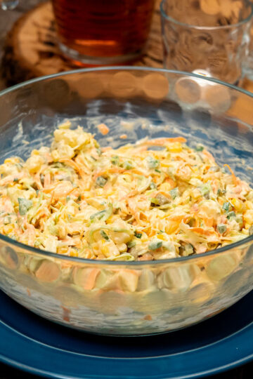 Servierfertiger Kartoffelsalat mit Gemüse und frischer Petersilie.