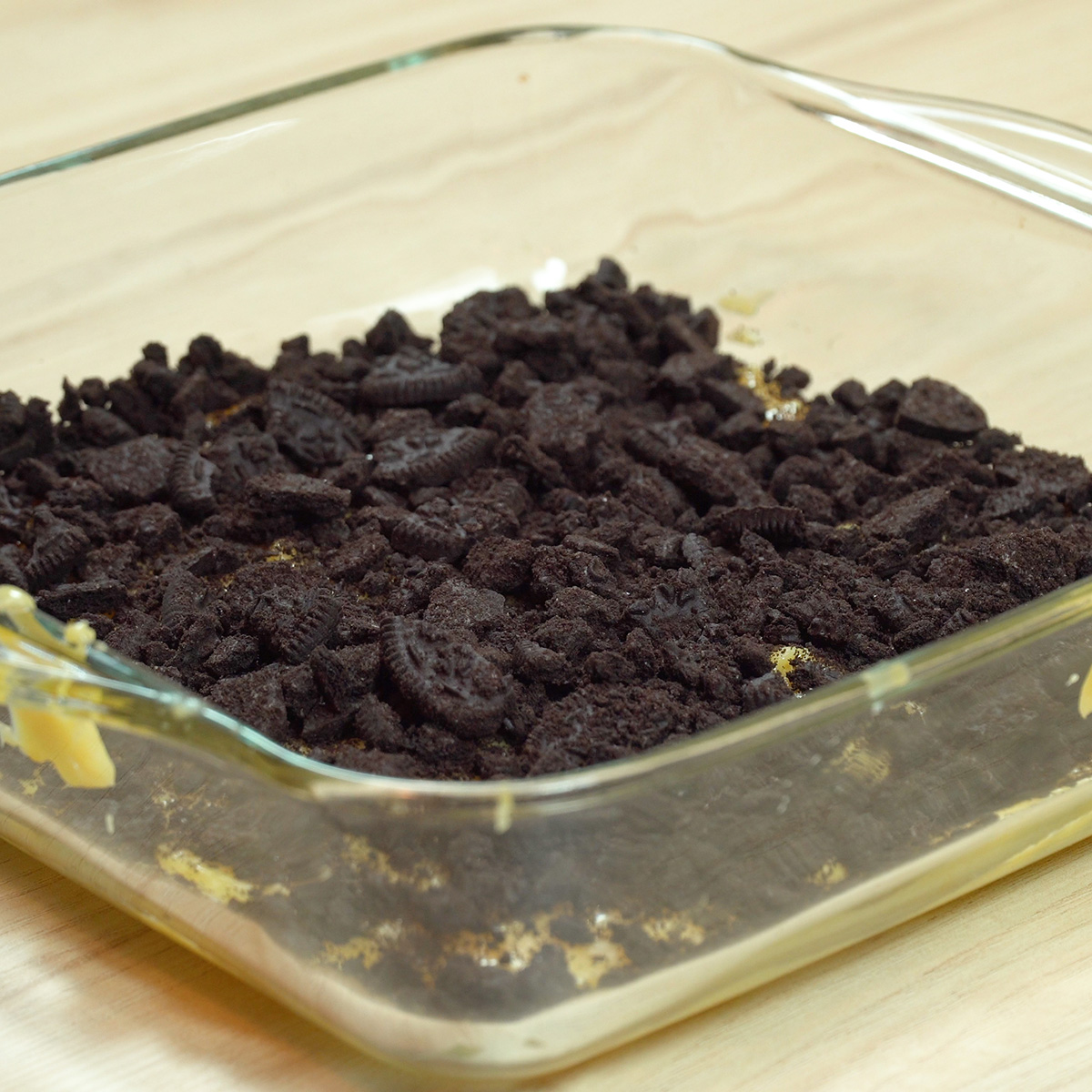 Helle Creme in der Form mit zerbröselten Oreo-Keksen darüber.