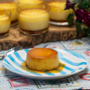 Karamellpudding mit Sahne wird auf einem Teller serviert.