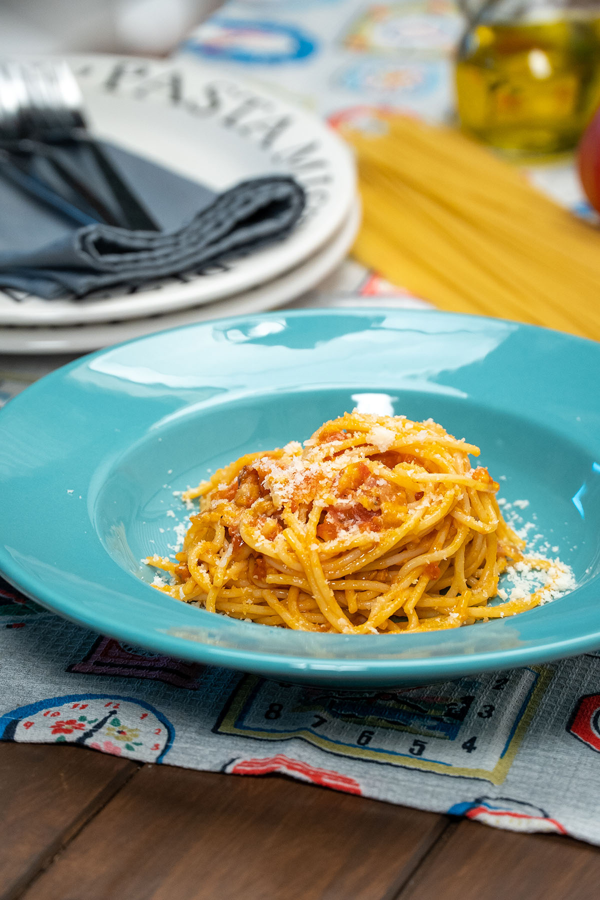 Angerichtete Spaghetti Amatriciana mit geriebenem Parmesan.