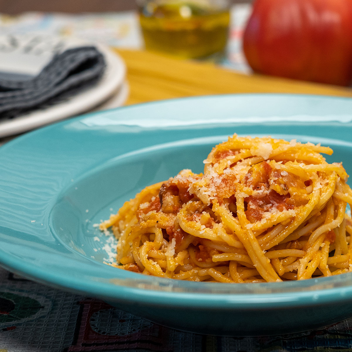 Spaghetti Amatriciana mit Tomatensauce und Parmesan auf einem Teller.