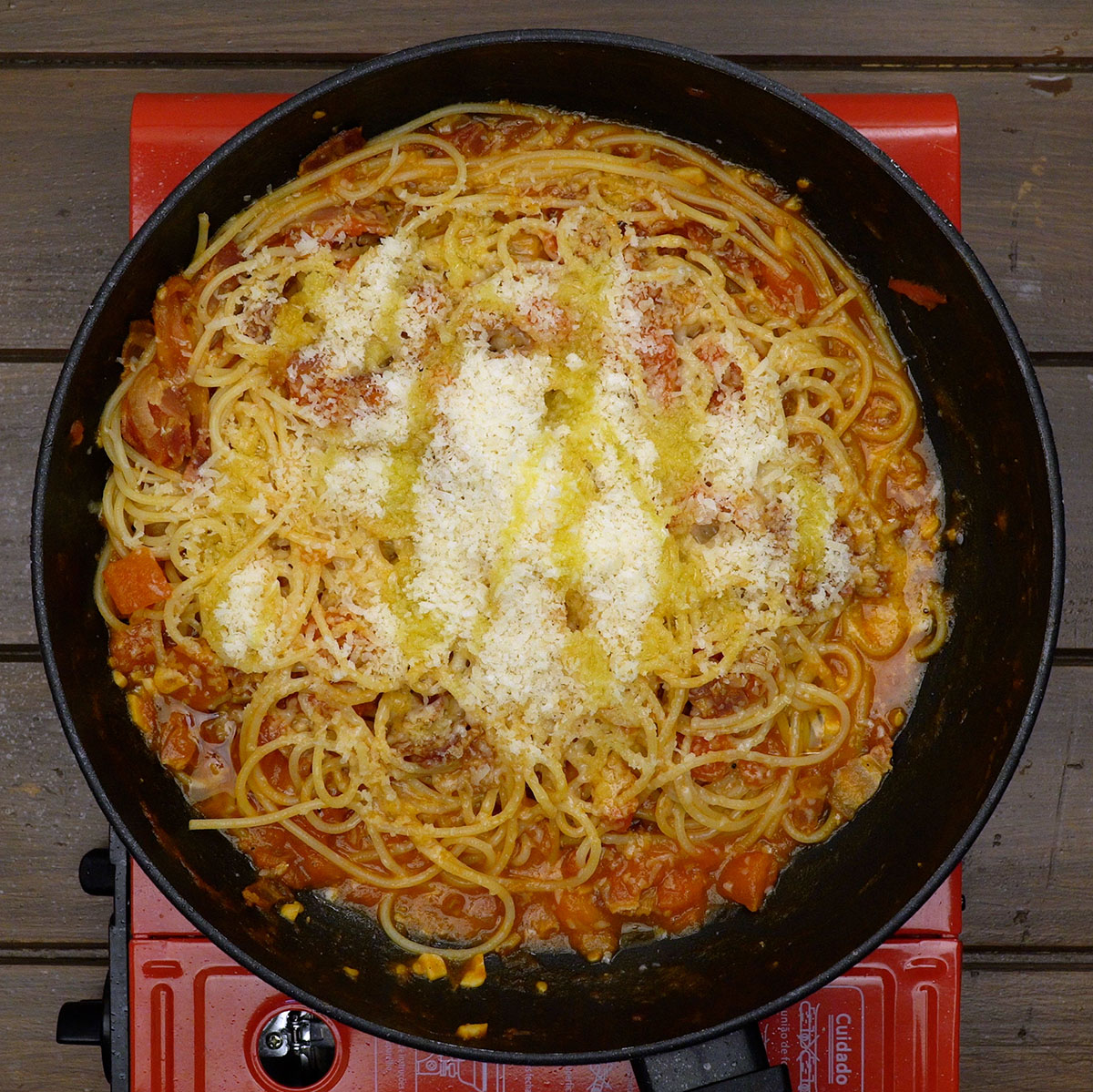 Geriebener Parmesan und etwas Olivenöl werden zu den Spaghetti gegeben.
